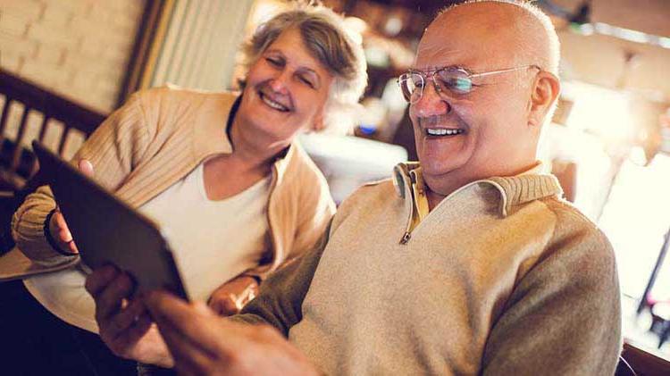Older couple looks at information on a tablet device.
