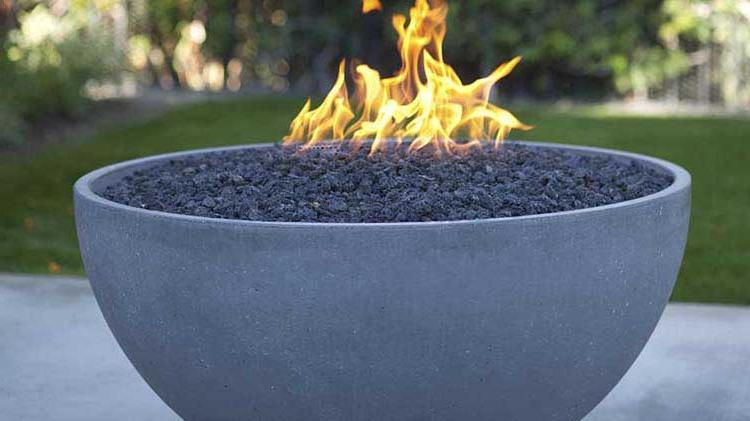 A flaming gas fire pit feature