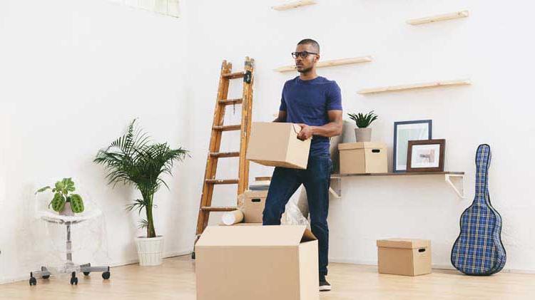 Person holding a box and thinking about what he needs to do to be ready for move in day.