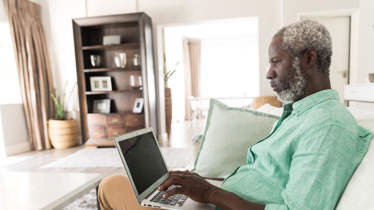 A man uses his laptop to work on his will and estate planning.